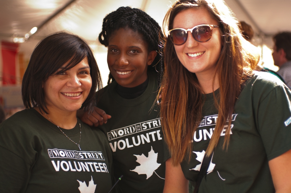 Three festival volunteers smiling at the camera.