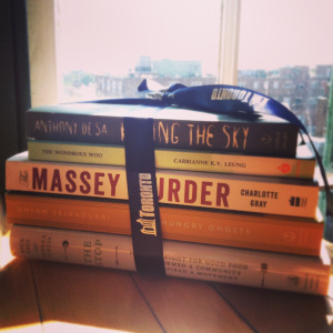 Stack of three books with a ribbon tied around them.